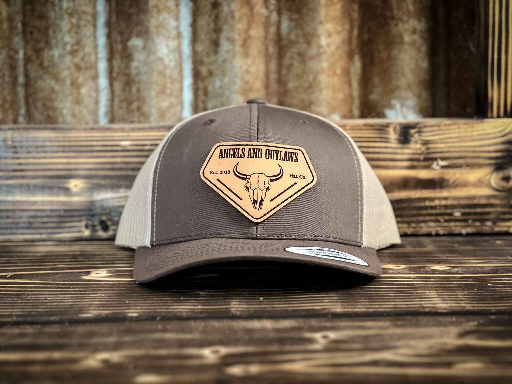 Coffee front Khaki back Mesh back trucker hat with Angels and Outlaws name and a bison skull engraved on a leather patch