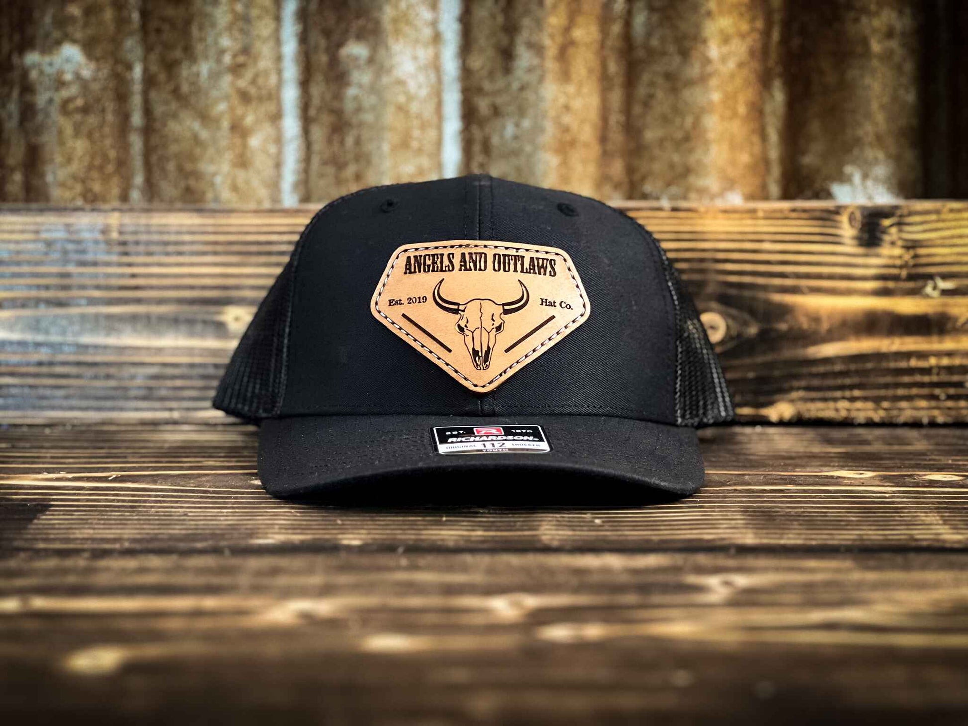 Black youth hat with Angels and Outlaws Co name and bison skull engraved on a leather patch