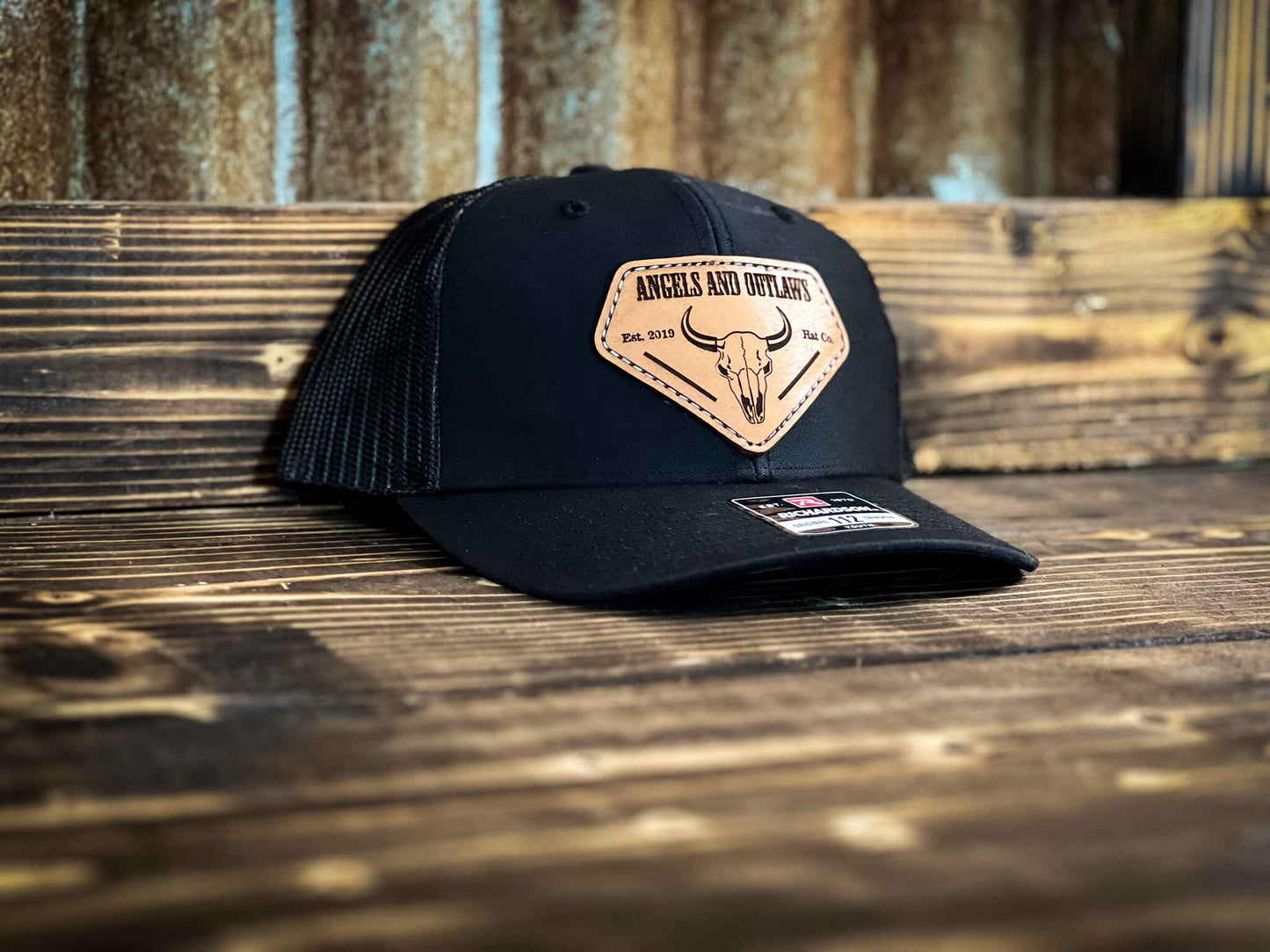 Black youth hat with Angels and Outlaws Co name and bison skull engraved on a leather patch